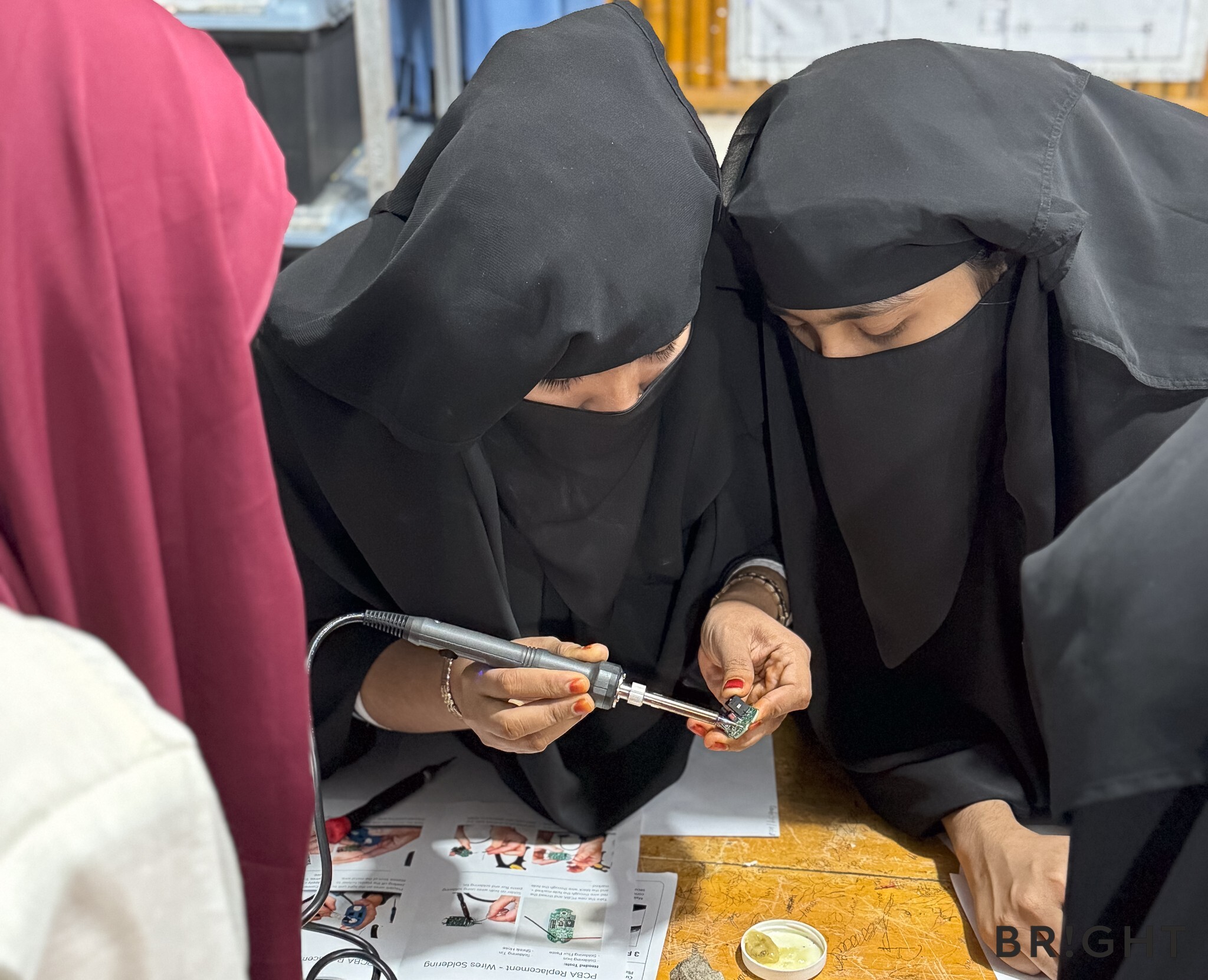 Trainees practise replacing the PCBA inside a BRIGHT SunBell solar lamp during a repair training session.